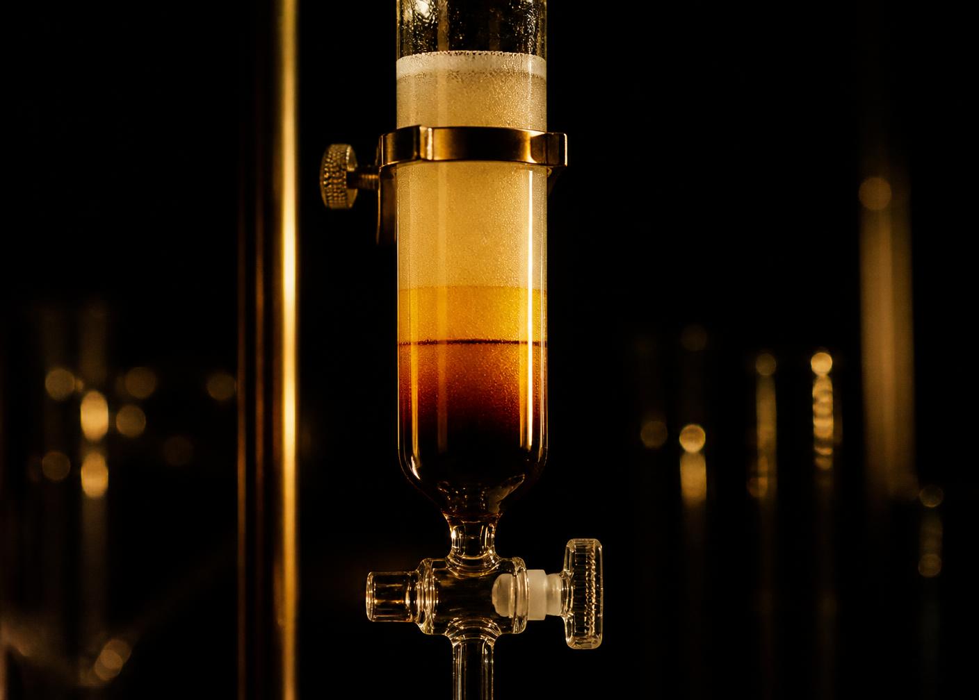 Chromatography column with amber solvent bands separating in glass
